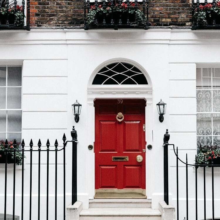 Red residential entry door with a glazed arch above